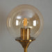 Modern long arm glass wall lamp with elegant glass ball shade and brass details, perfect for bedrooms or living rooms.