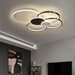 Modern minimalist overlapping circular ceiling light fixture in a contemporary living room setting.