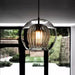 Modern glass double shade pendant light, perfect for contemporary home decor, hangs elegantly in a room with a garden view.