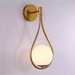 Gold Nordic Elegance Drop Wall Lamp with LED light and frosted glass shade, mounted on wall, showcasing a sleek, modern design.