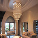 Elegant grand spiral crystal chandelier illuminating a luxurious living room with modern decor and high ceilings.