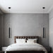 Modern double-head LED pendant light in minimalist bedroom setting.