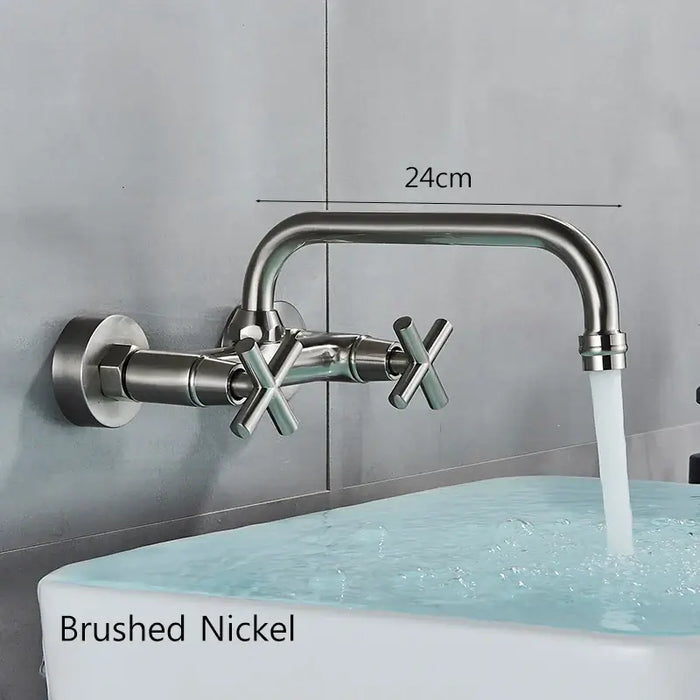 Wall-mounted brushed nickel kitchen mixer tap with dual handles and a 360-degree rotatable spout, water flowing into a sink.