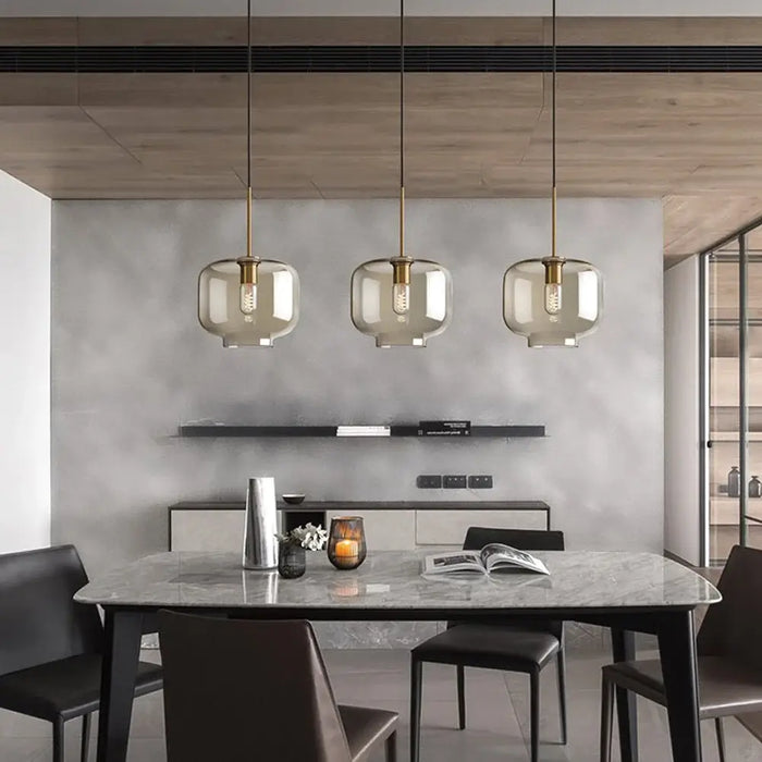 Modern industrial glass pendant lamp illuminating a contemporary dining area with soft ambient lighting.