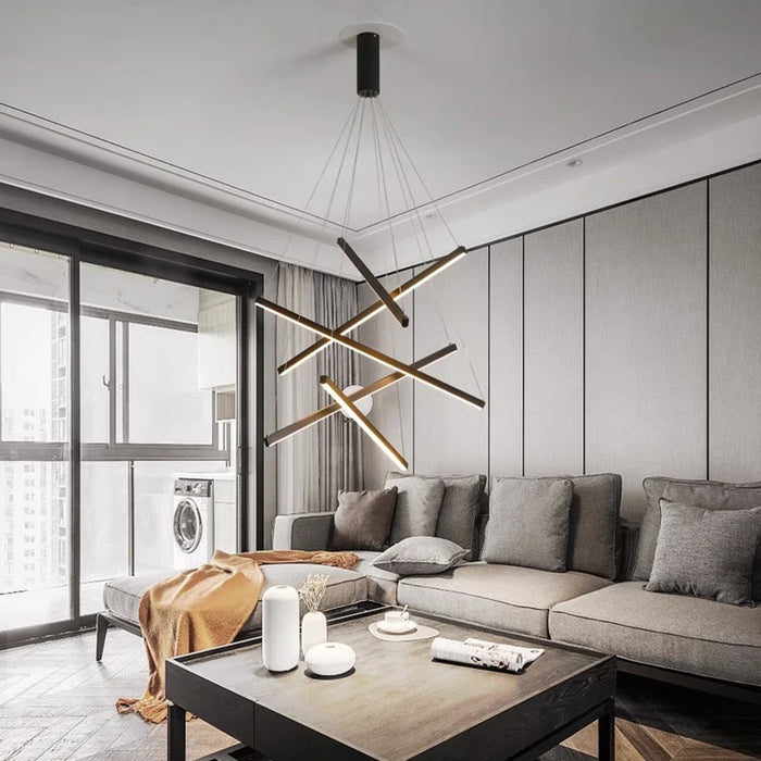 Modern smart chandelier with adjustable lighting, installed in a contemporary living room with gray furniture and large windows.