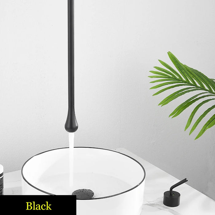 Black water drop ceiling faucet with sleek design, dispensing water into white basin, enhancing modern bathroom decor.