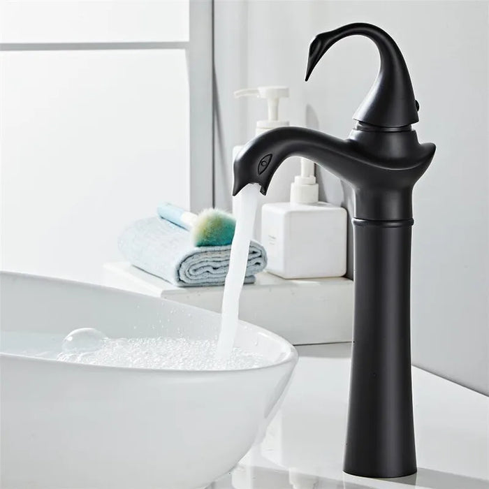 Tall Swan Basin Faucet in black with a modern design, elegantly pouring water into a white basin, enhancing bathroom luxury.