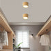 Modern wood grain LED ceiling downlight illuminating a stylish room with neutral decor and sleek storage spaces.