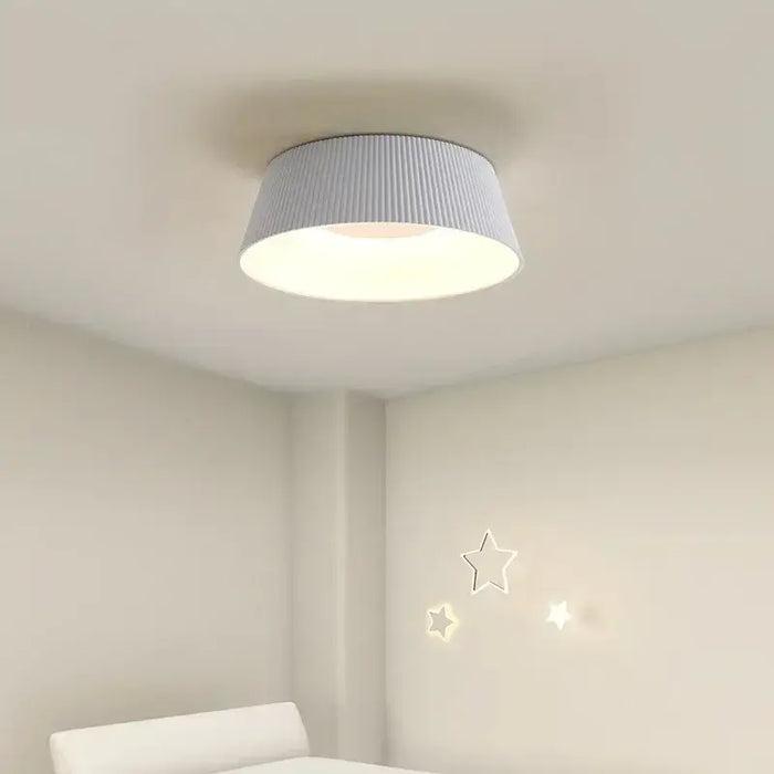 Modern LED ceiling light with sleek design, providing stylish illumination in a bright room with star wall decals.