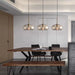 Modern industrial dining area with glass pendant lamps above wooden table and chairs