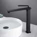 Modern black brass basin faucet with single-handle design, deck-mounted next to a stylish white basin in a contemporary bathroom setting.