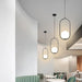 Modern cage chandeliers with LED bulbs hanging in a stylish dining area, showcasing elegant and contemporary interior lighting design.