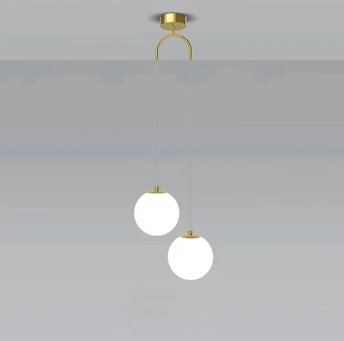 Modern round glass pendant light with dual LED bulbs and brass finish for stylish interior lighting.