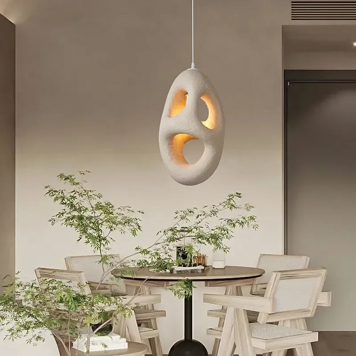 Modern Wabi Sabi pendant light hanging in a minimalistic dining area, showcasing Japanese style and resin design with LED illumination.