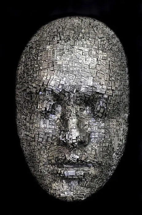 abstract face sculpture made of metallic type blocks on a dark background