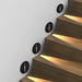 Staircase with embedded PIR sensor step lights illuminating wooden steps in a modern design.