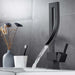 Luxury brass square basin mixer faucet with water flow in modern bathroom setting.