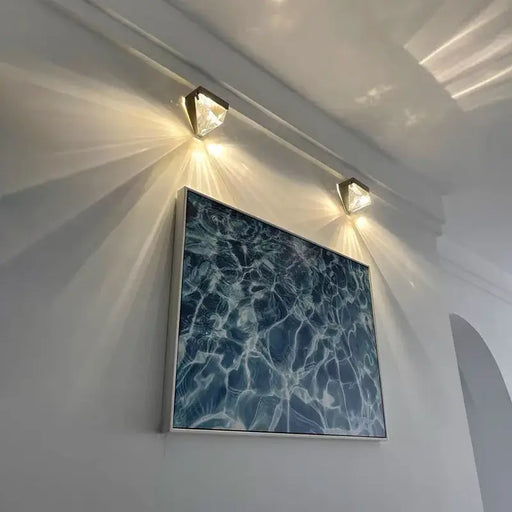 luxury crystal wall sconce illuminating modern artwork on white wall