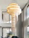 Modern Loft Spiral Chandelier with golden tassels in a spiral staircase design hanging in a luxurious living room.