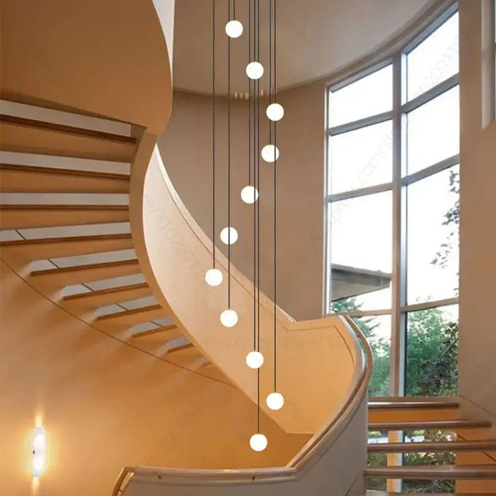 Minimalist Multi-Head LED Chandelier illuminating a modern spiral staircase with elegant design and adjustable height.