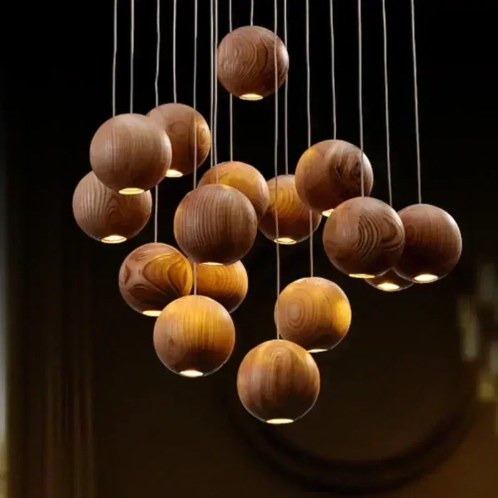 Solid wood pendant light with handcrafted wooden spheres for warm ambient lighting in home or hospitality spaces.