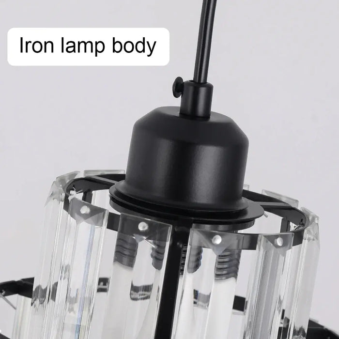 Close-up of iron lamp body on tiered crystal glass pendant light fixture.