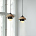 Nordic wood round pendant lights with colored shades hanging in front of a window, featuring minimalist design and warm illumination.