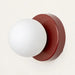 Modern LED wall sconce with frosted glass globe on a red base for cozy ambiance in small spaces.