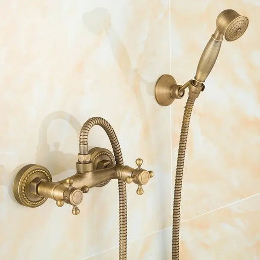 Antique bronze bath mixer with hand shower and dual handles on a wall-mounted faucet set in a classic bathroom setting.