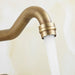 Antique brass faucet with water flowing from swivel spout, showcasing elegant design and durable construction.