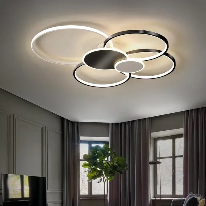 Minimalist overlapping circular ceiling light illuminating a modern living room interior.