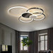 Minimalist overlapping circular ceiling light illuminating a modern living room interior.