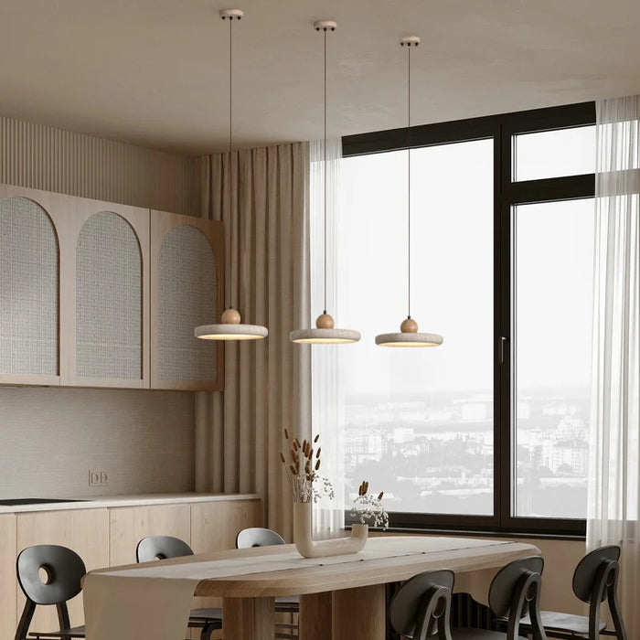 Modern kitchen with retro natural stone art pendant lights in yellow travertine hanging above a wooden dining table.