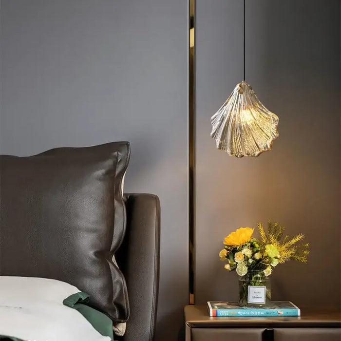 Elegant glass shell pendant ceiling light with electroplated finish, illuminating a cozy bedroom setting with warm LED glow.