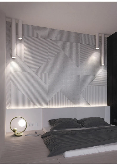 Modern bedroom with long tube LED ceiling lamps illuminating a stylish textured wall design.