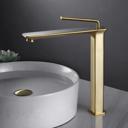 Brass basin faucet with single-handle design for hot and cold water, next to a white ceramic sink, enhancing bathroom style.