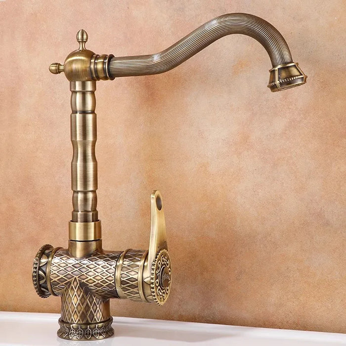 Antique bronze deck-mount basin faucet with intricate design and single-handle for hot and cold water control.