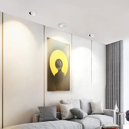 Modern living room with 360° adjustable LED recessed downlights illuminating a sofa and wall art.