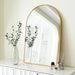 Large arch mirror with a sleek aluminum frame on a dresser, reflecting modern home decor and accents.