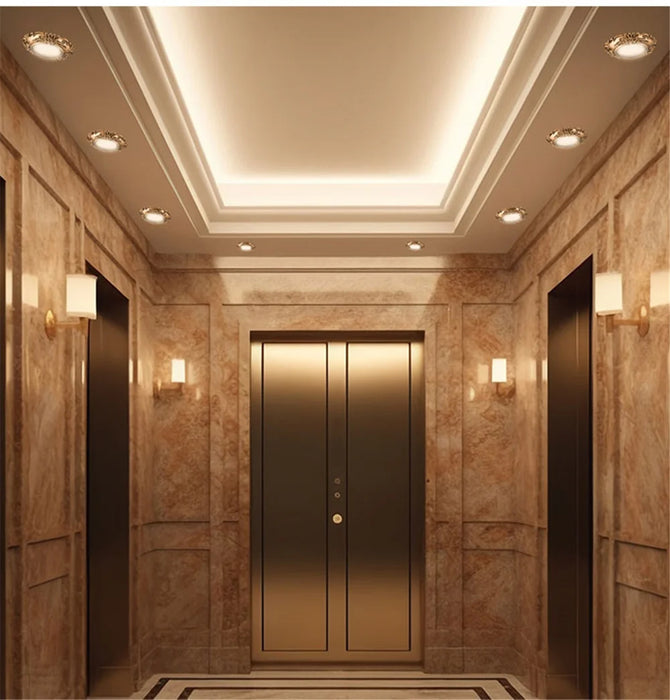 Elegant elevator lobby with marble walls and European retro bronze LED downlights for ambient illumination