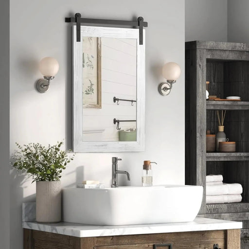 Rustic barn door mirror in a farmhouse-style bathroom with solid wood frame and vintage decor elements.