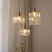 Modern retro glass pendant lamp with copper finish, textured glass shades creating warm ambiance in room decor.