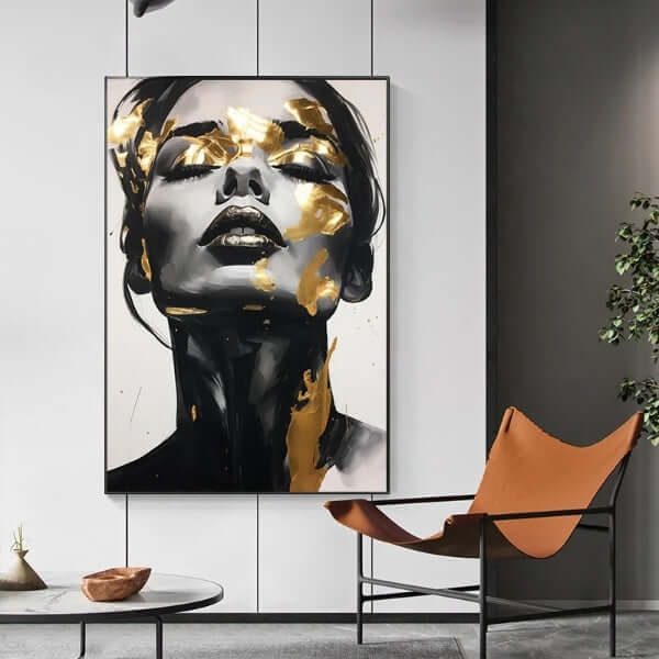 Abstract woman portrait with black and gold accents on canvas, displayed in a modern living room setting.