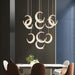 Elegant adjustable crescent moon chandelier above modern dining table with brown chairs, enhancing celestial charm and luxury.