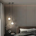 Modern frosted glass globe chandelier illuminating a stylish bedroom with elegant hanging lighting fixtures.