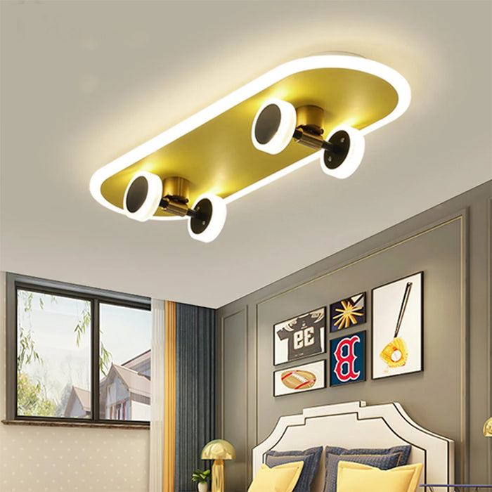 Skateboard ceiling lamp in yellow and black, modern acrylic design for children's room, mounted above bed with decorative wall art.