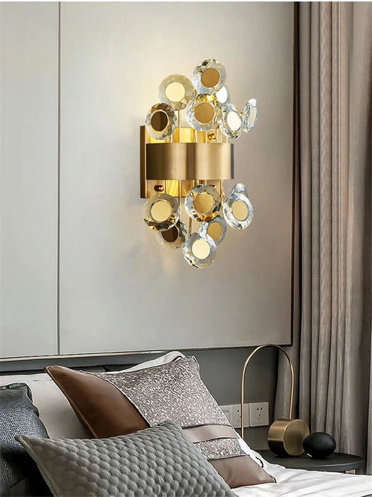 Modern luxury LED crystal wall lamp installed above a bed in a stylish bedroom setting.