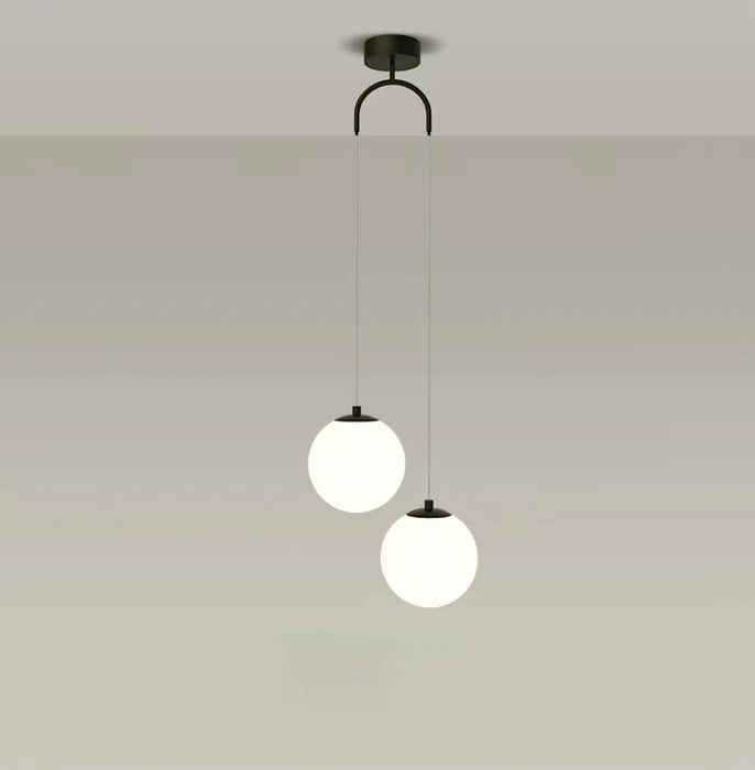 Modern round glass pendant light with dual globes and black iron finish, perfect for bedroom, living room, or dining room lighting.