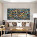 Vibrant Pollock-inspired abstract canvas with explosive colors on a wall above a leather sofa in a modern living room.