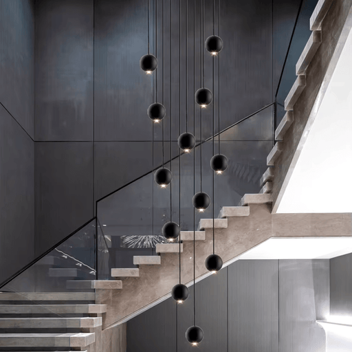 Modern LED orb chandelier hanging in a stairwell, featuring sleek design and adjustable height for contemporary interior spaces.